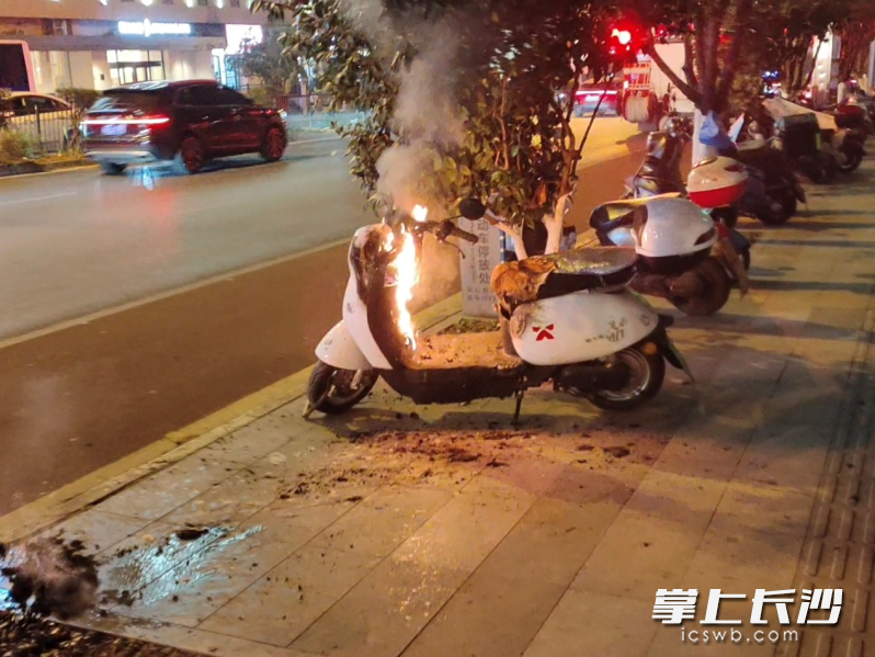 一辆停靠在路边的电动自行车突然起火。 均为长沙晚报通讯员罗霜操摄
