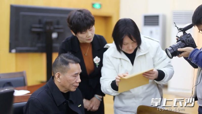 盲文老师给刘先生（左一）念判决书的内容。 长沙晚报全媒体记者 李广军 摄
