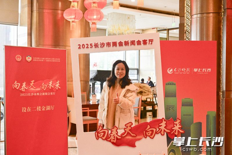 参会代表在长沙晚报两会会客厅主题相框打卡留念。