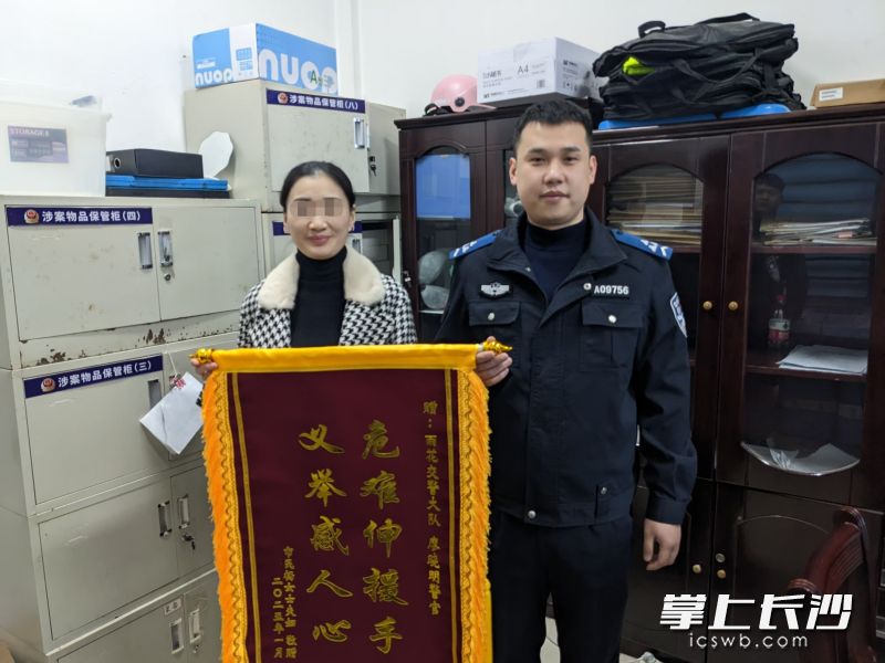 市民给辅警廖晓明送上一面印着“危难伸援手 义举感人心”的锦旗。长沙晚报通讯员 杨哲 供图