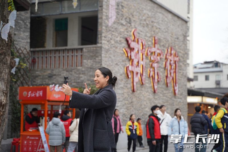 来自哥伦比亚的Marcela在长沙潮宗街边游览边拍摄vlog，十分开心。 均为长沙晚报全媒体记者刘晓敏摄