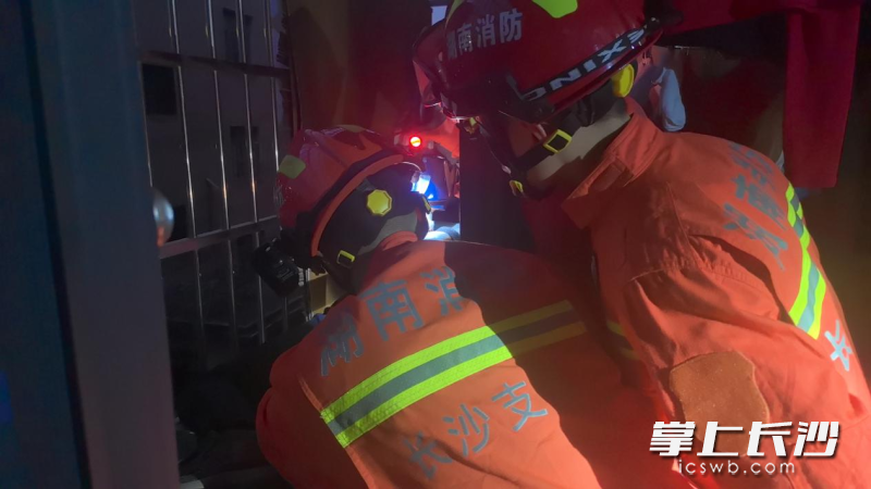 消防员帮助卡在防盗网上的老人脱困。长沙晚报通讯员 阮鹏霖 摄