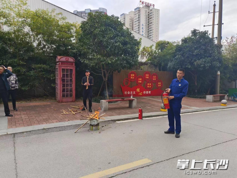 消防宣传员正在向居民介绍灭火器材的使用方法。 长沙晚报通讯员 程锡 摄