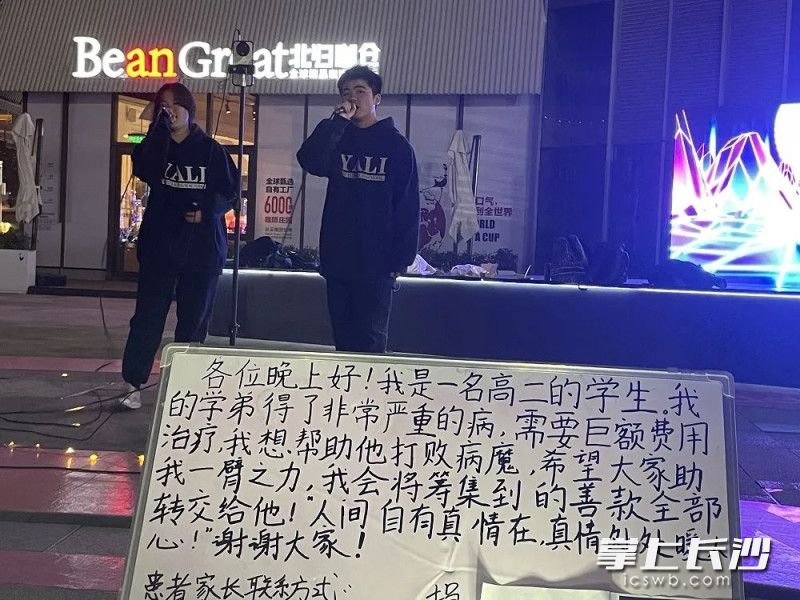 手写的白板吸引了爱心人士的加入，不少路人纷纷掏出手机扫码捐款。 长沙晚报全媒体记者 林暘 摄