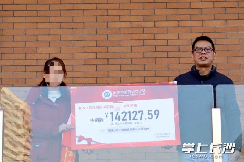 休学典礼上，雅礼书院中学将线下募集的爱心款交到患病同学家长手中。 长沙晚报通讯员 苏珊 供图