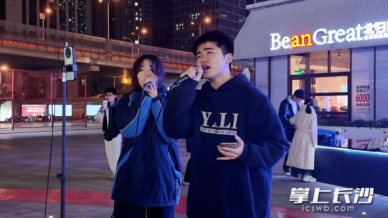 邓薪奥（右）和小伙伴街头义唱，用歌声为患病同学筹集善款。 长沙晚报全媒体记者 林暘 摄