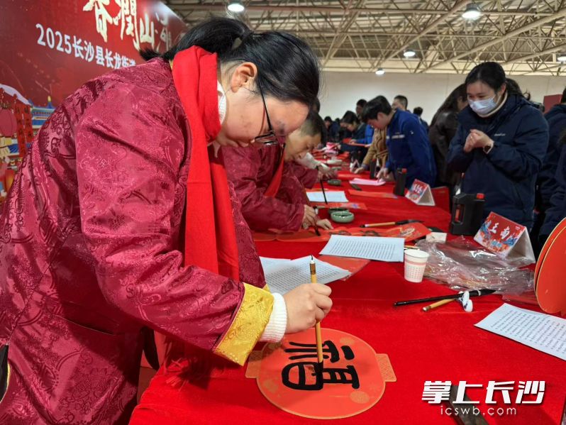 来自长沙市书法家协会、长沙经开区书法家协会、山河智能书法家协会的老师正在手写春联和“福”字。