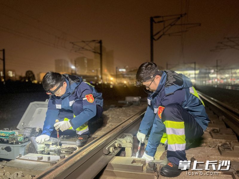 岳钦松（左）和工友刘祎调整道岔缺口。