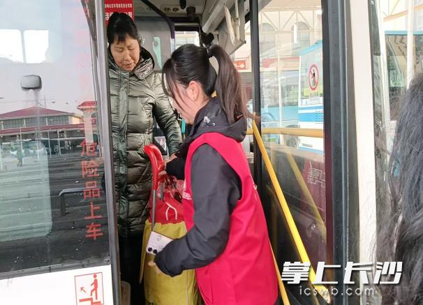一名青年志愿者帮旅客把行李送上车。均为长沙晚报通讯员 黄盈 供图
