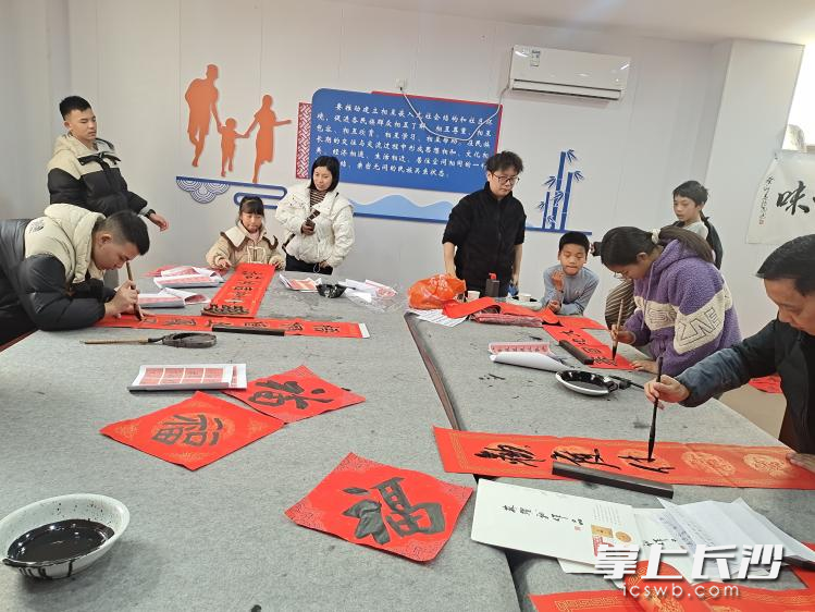 小朋友们和艺术家一起写“福”字、写春联。