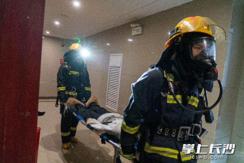 消防人员争分夺秒搜寻“被困人员”并将其安全救出。