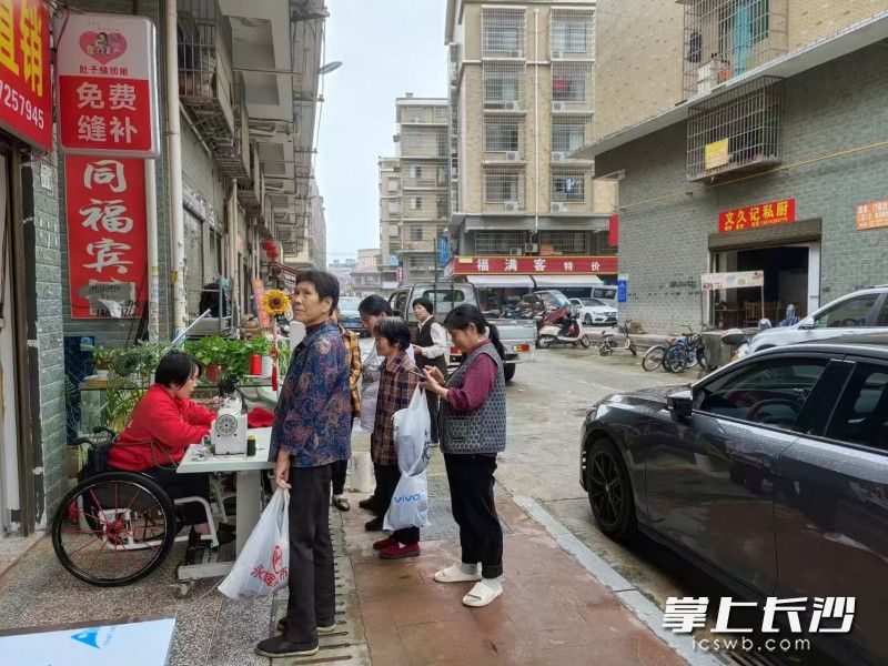 唐漫霞当街进行义务缝补活动，受到群众欢迎。