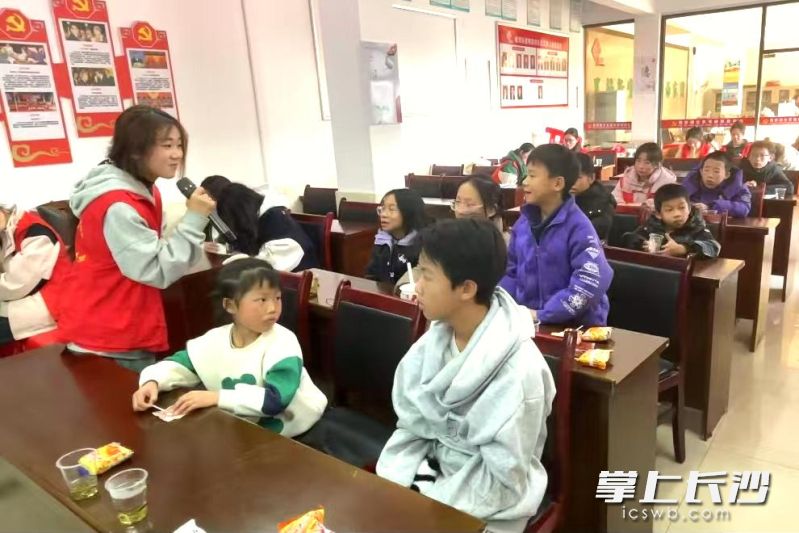 在梅家田社区授课现场，来自长沙职业技术学院的志愿服务队员和孩子们积极互动。
