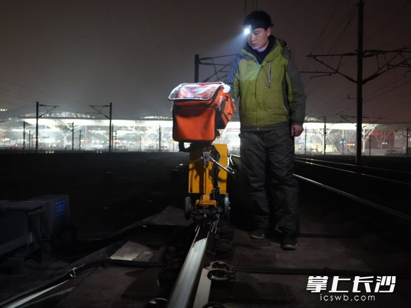 长沙南沪昆探伤工区副工长胡景推着钢轨探伤仪检查道岔。 均为 全媒体记者 吴鑫矾 通讯员 孙庆 向奕帆 摄