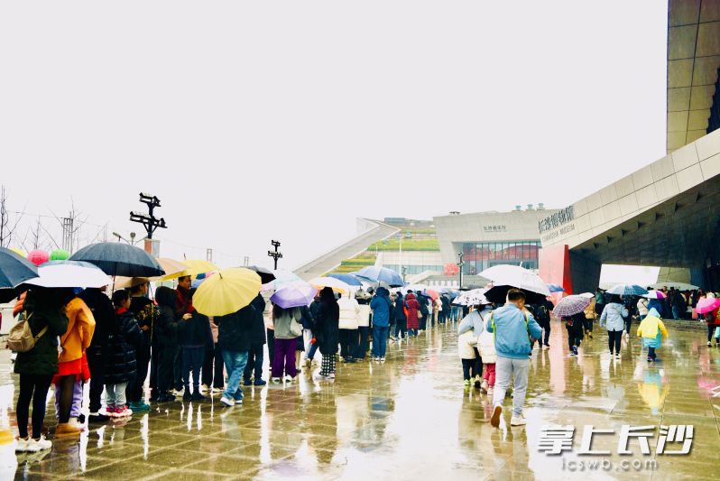 游客们冒雨在长沙博物馆门口排成长龙。 游客们冒雨在长沙博物馆门口排成长龙。