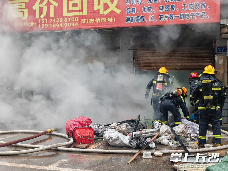 消防员在扑救废品店火灾。