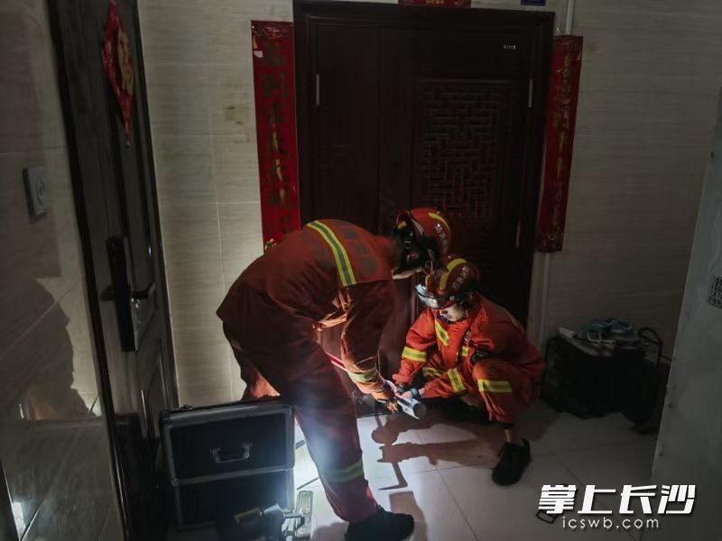 消防人员对大门进行破拆以营救被困人员。 长沙晚报通讯员 胡承婧 摄