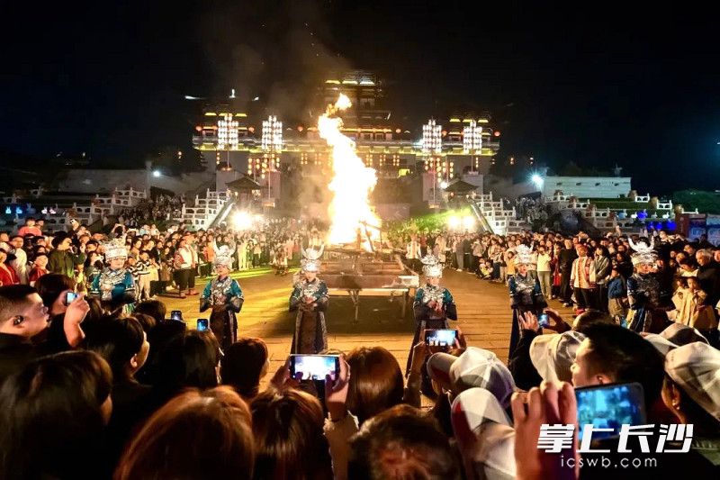 游客围着篝火舞之蹈之。 游客围着篝火舞之蹈之。