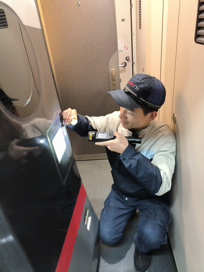 张扬检修动车组列车车厢内的设备。