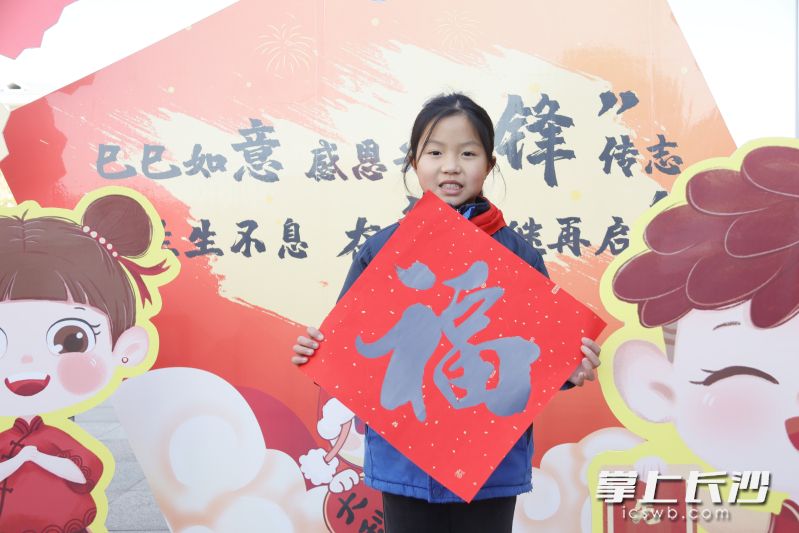 拿着“福”字照相打卡。