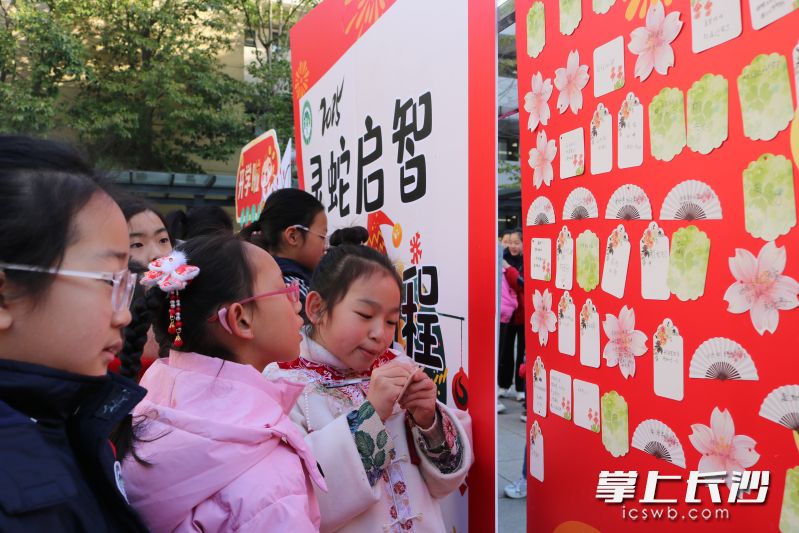 同学们纷纷写下自己的新年心愿望，贴在“心愿墙”上。