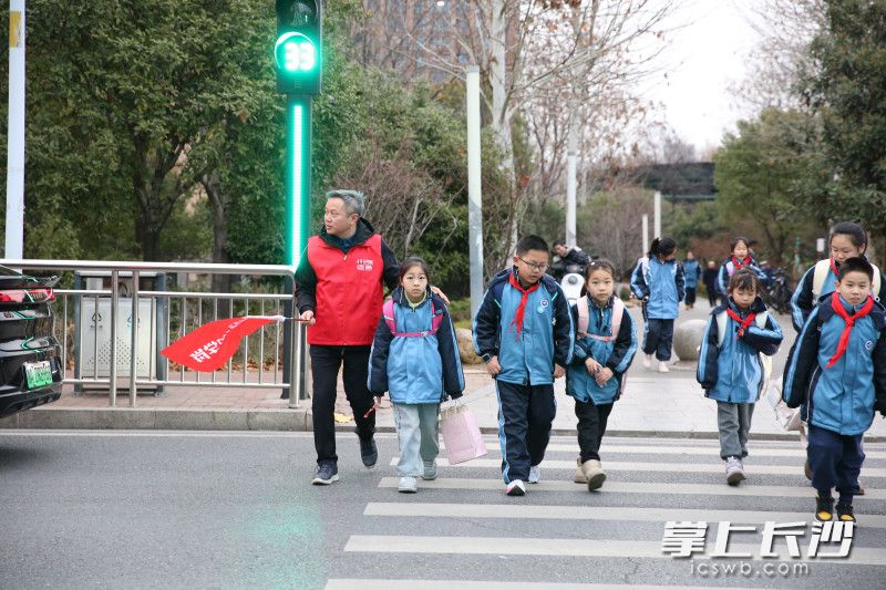 “长沙好人”张家贵和井湾子街道的雷锋志愿者们分别来到雅境中学和万境小学门前守护学生安全。 均为长沙晚报通讯员高兴摄