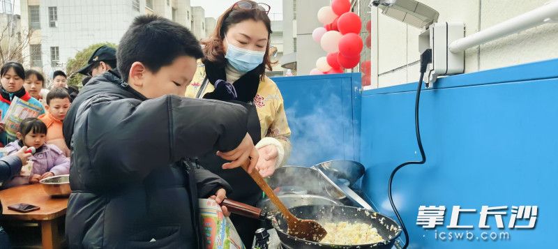 从校长妈妈手里拿过锅铲制作扬州炒饭。  长沙晚报通讯员 郑薇 赵娟 摄