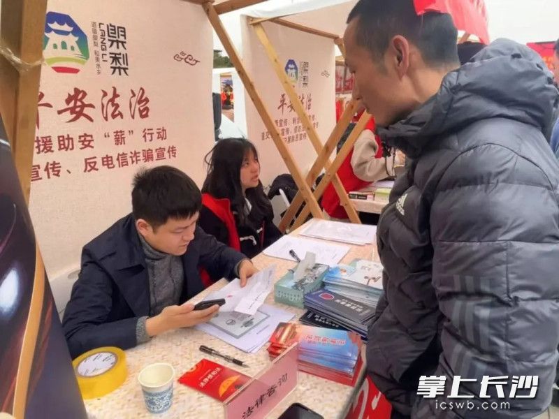 法律咨询摊位前围满了前来咨询法律问题的群众。