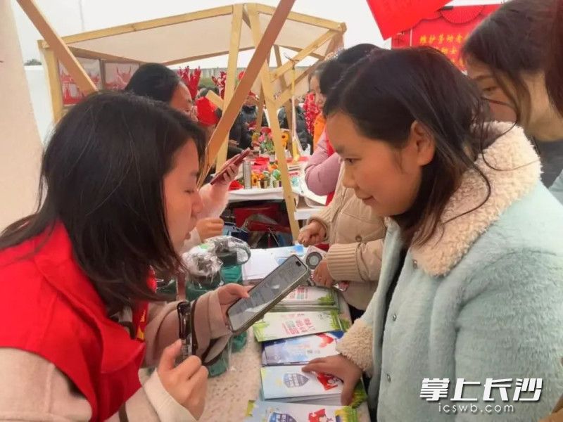 群众纷纷掏出手机扫码关注工作人员手中的“法治二维码”。