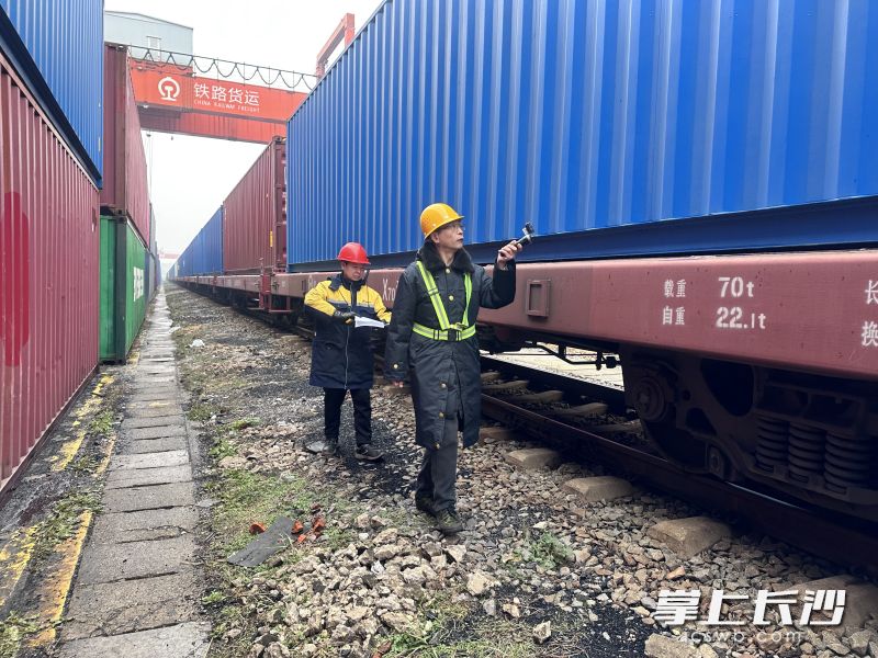 在长沙北铁路货场,货装值班员陈沙安正在对中欧班列进行检车。 均为长沙晚报通讯员 袁一萍孟祥琳摄 在长沙北铁路货场,货装值班员陈沙安正在对中欧班列进行检车。 均为长沙晚报通讯员 袁一萍孟祥琳摄