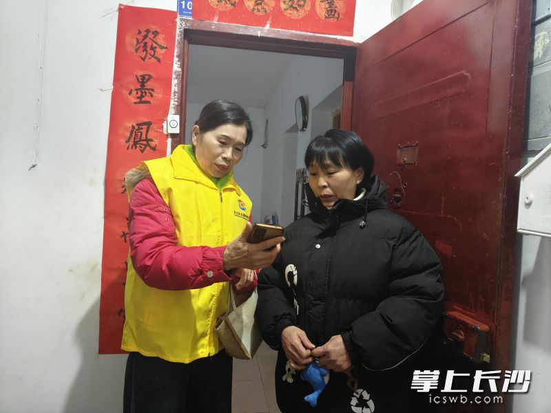 邢庆英（左一）深入社区居民家中，为社区居民现场普及反诈知识。 通讯员供图