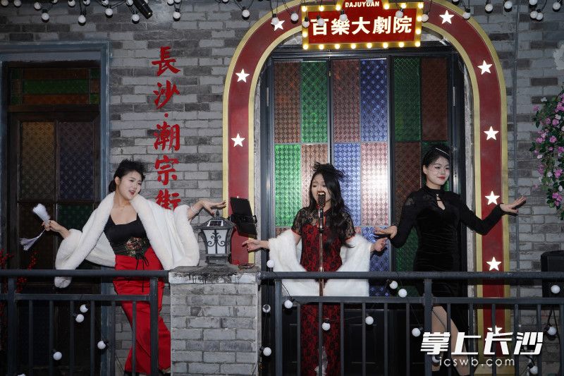 酒馆二楼阳台上的“百乐大剧院”里，一位女歌手领着两位女舞者载歌载舞。
