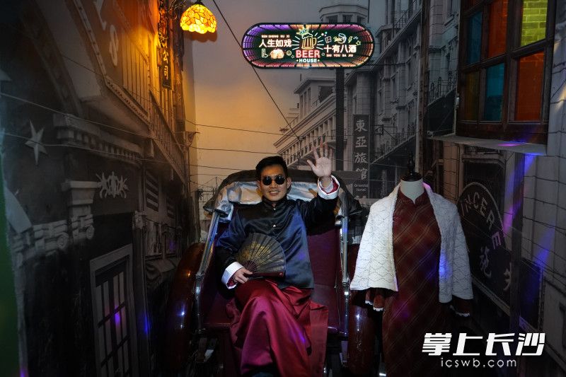 有人身着老板服饰坐在黄包车上体验拍照。