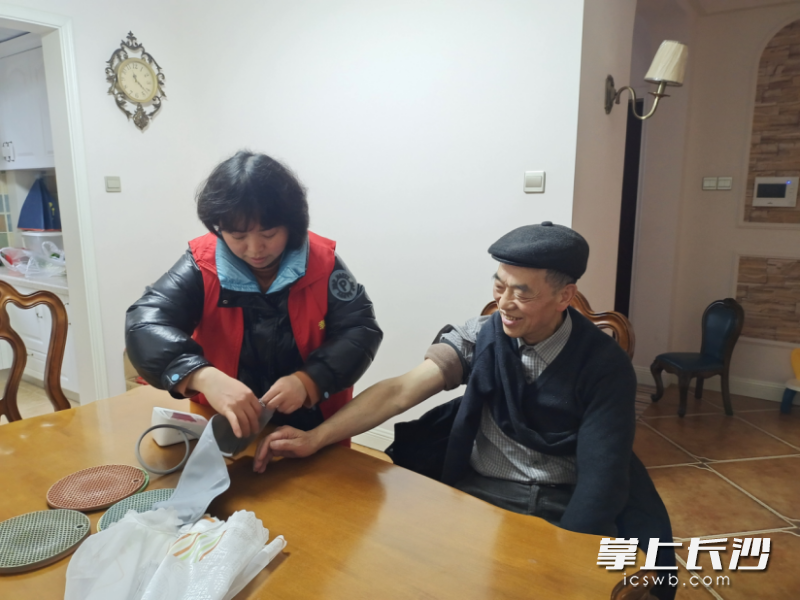 居家养老服务中心工作人员为老人进行简单的健康检查。