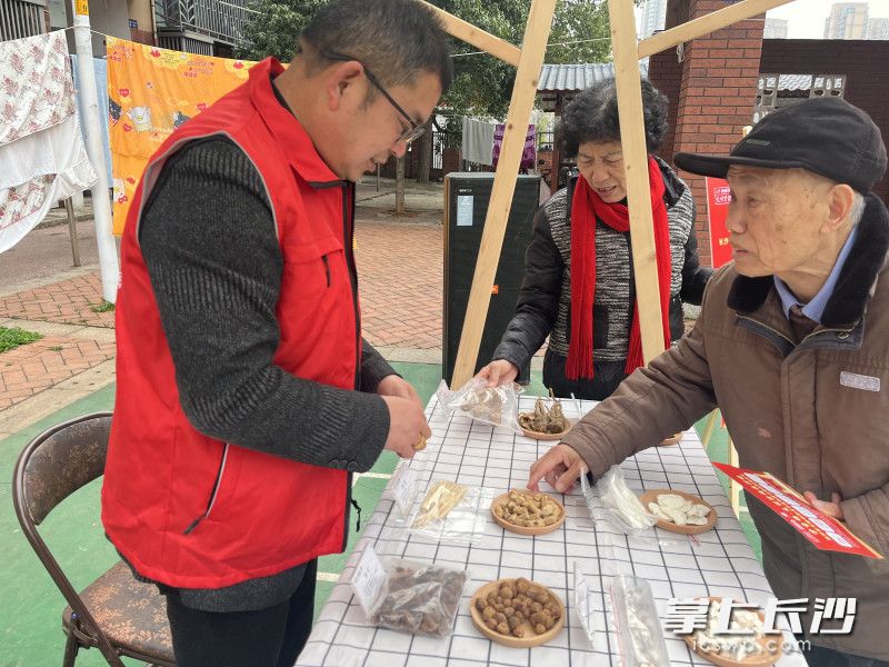 在中药辨识展位前，居民们好奇地辨认着各类药材，不时向工作人员询问功效。