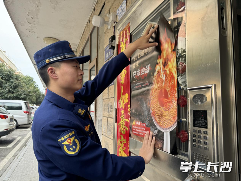消防宣传员正在张贴海报。 长沙晚报通讯员 谢海鹏 摄