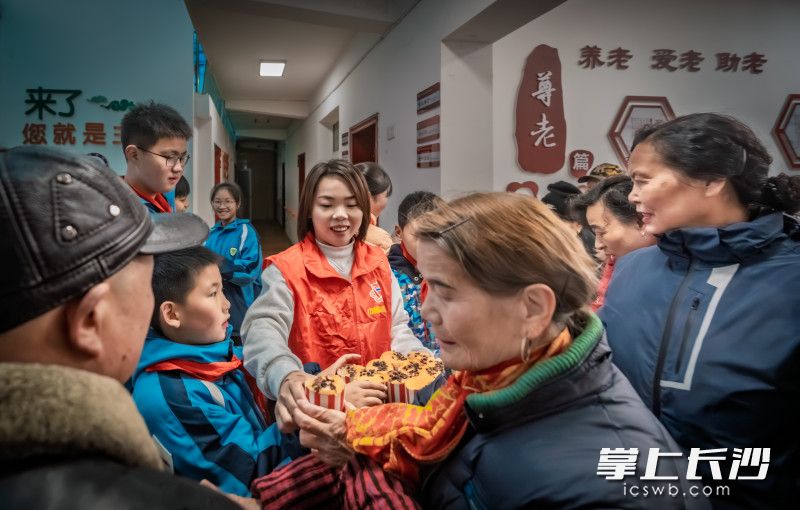 3月5日中午，钟焱焱和孩子们将做好的蛋糕送给社区老人。