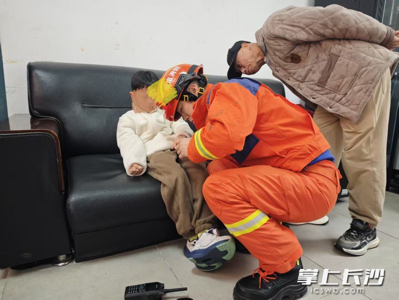 消防员在帮助小男孩解困。 长沙晚报通讯员 程永康 摄