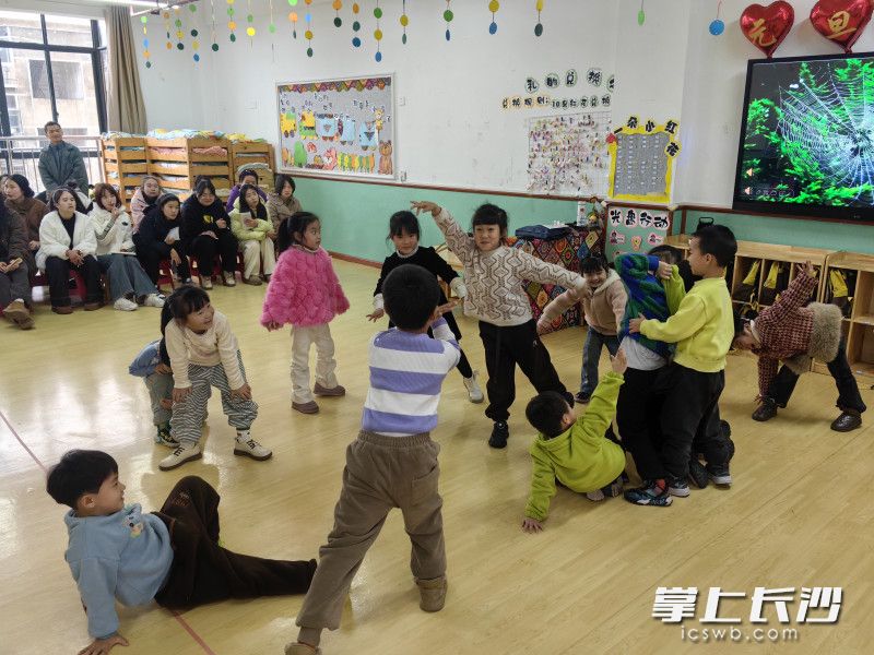 大班艺术活动《会跳舞的蜘蛛》课上，小朋友在联合起来“织网”。
