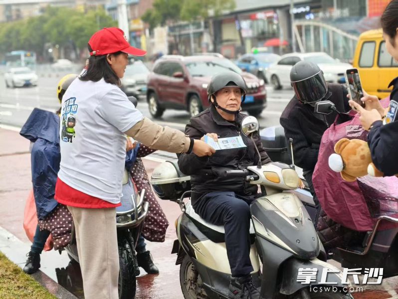 活动中，义警及社区志愿者向过往行人发放精美的交通安全宣传手册。长沙晚报通讯员 吴莎 供图