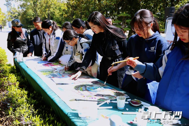 3月19日，在画展现场，众多学生尝试在夏布上作画。长沙晚报全媒体记者 颜开云 摄