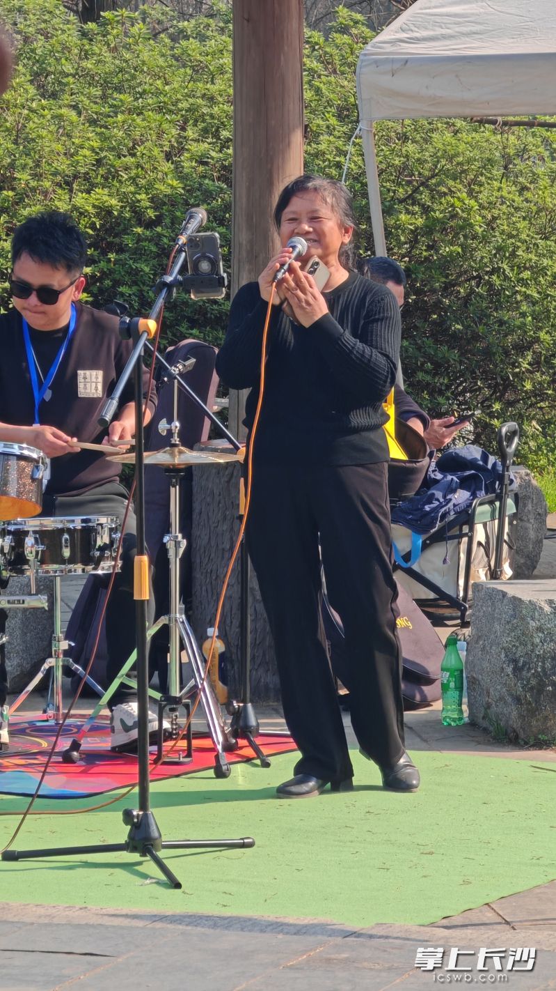 脱下工装，环卫工大姐在乐队老师伴奏下高歌一曲。