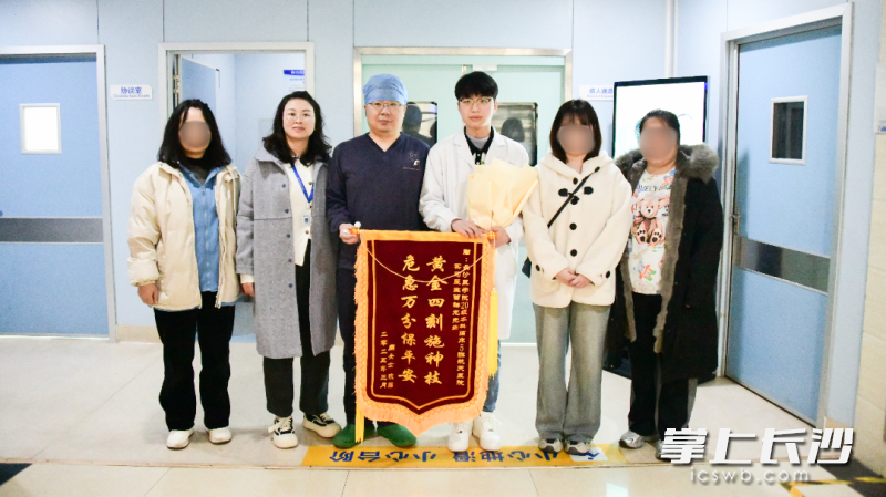 被救女子在家属陪同下将鲜花、锦旗与感谢信送给湖南航天医院的医护人员，并与实习医生曾祥龙（右三）及刘涛医生合影留念。 均为通讯员供图
