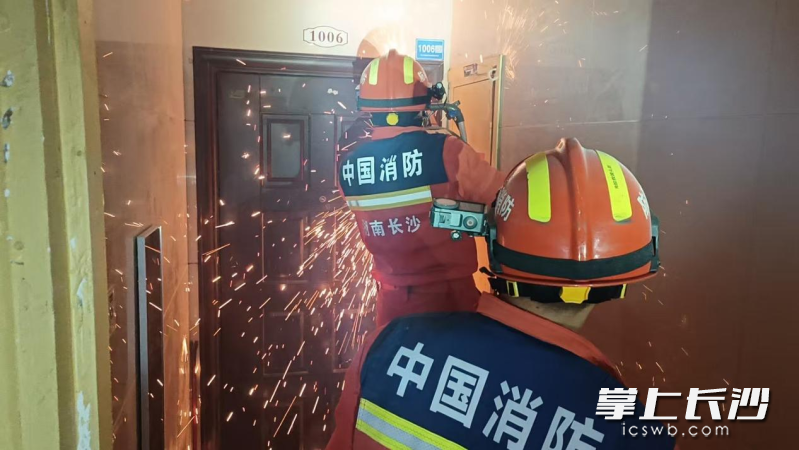 消防员破拆门锁营救被困业主。 长沙晚报通讯员 尹志杰 摄