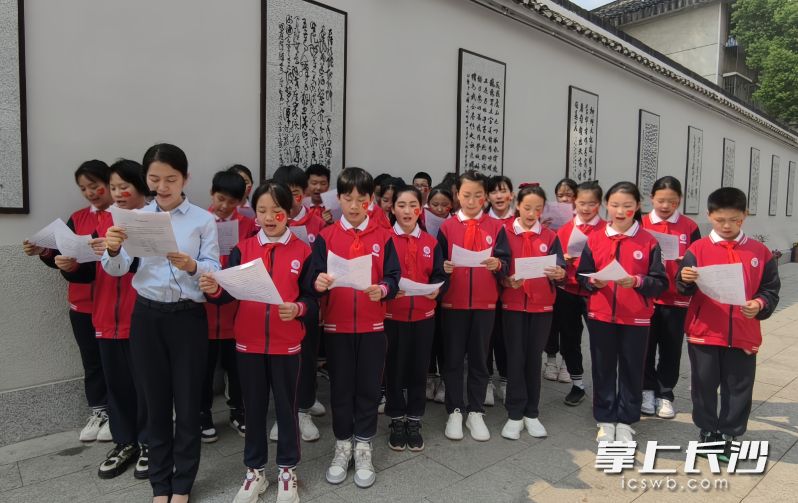 学生参观诗词文化墙并诵读蔡和森同志的《少年行——北上过洞庭有感》。