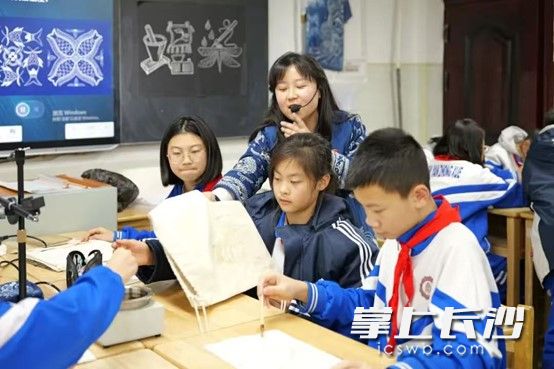 学生在何方蓉老师的指导下进行蜡染制作。