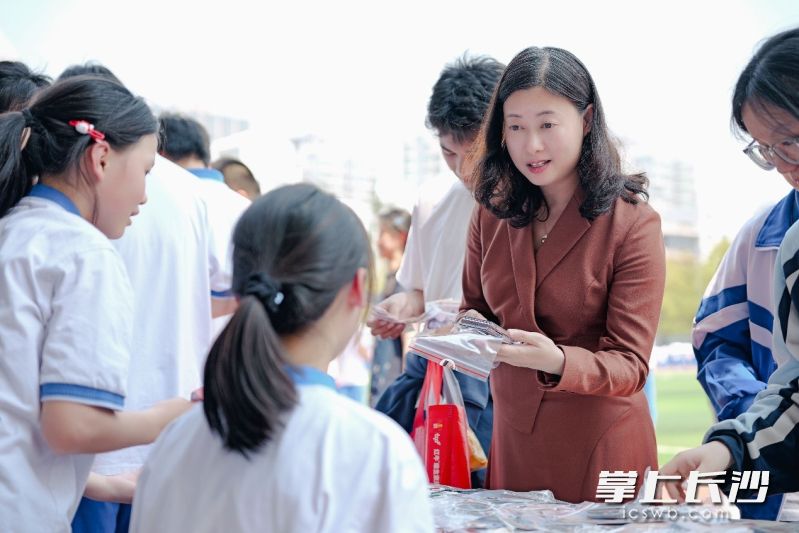 长沙市实验中学校长张桃购买义卖品，为义卖活动献爱心。