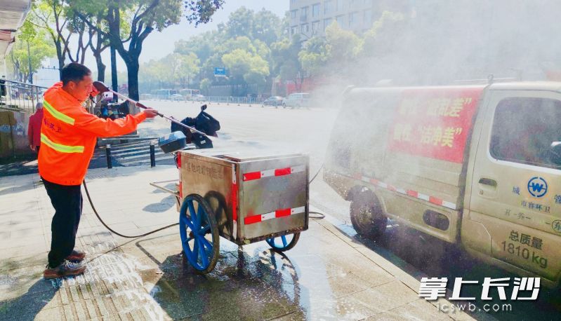 环卫工人用高压水枪冲洗移动垃圾车。均为长沙晚报通讯员 袁佳乐 摄