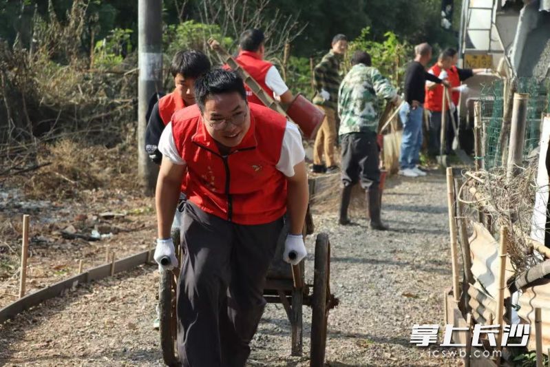 志愿者帮唐老修路。
