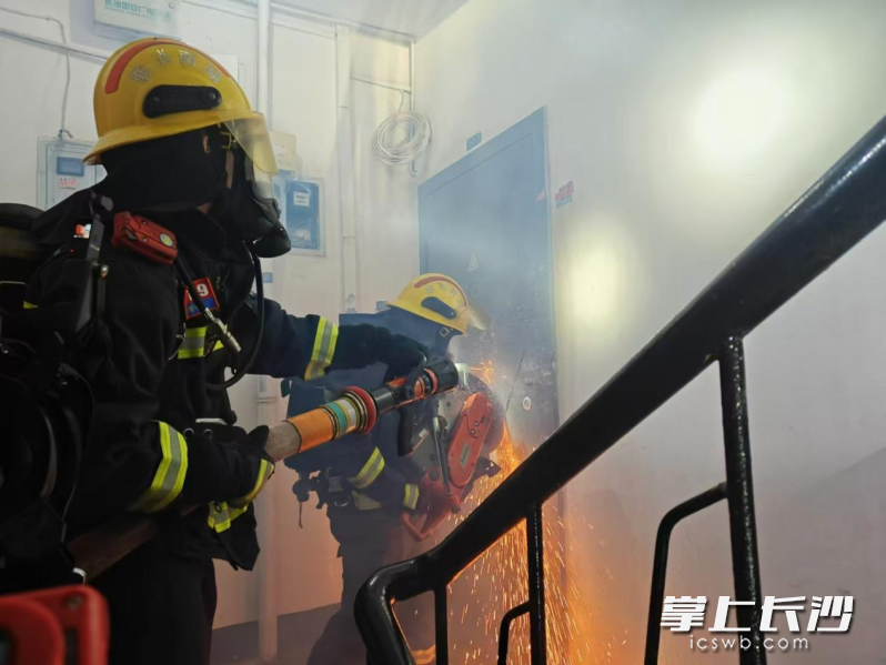 消防员破门救火。 长沙晚报通讯员 李浩 摄 消防员破门救火。 长沙晚报通讯员 李浩 摄